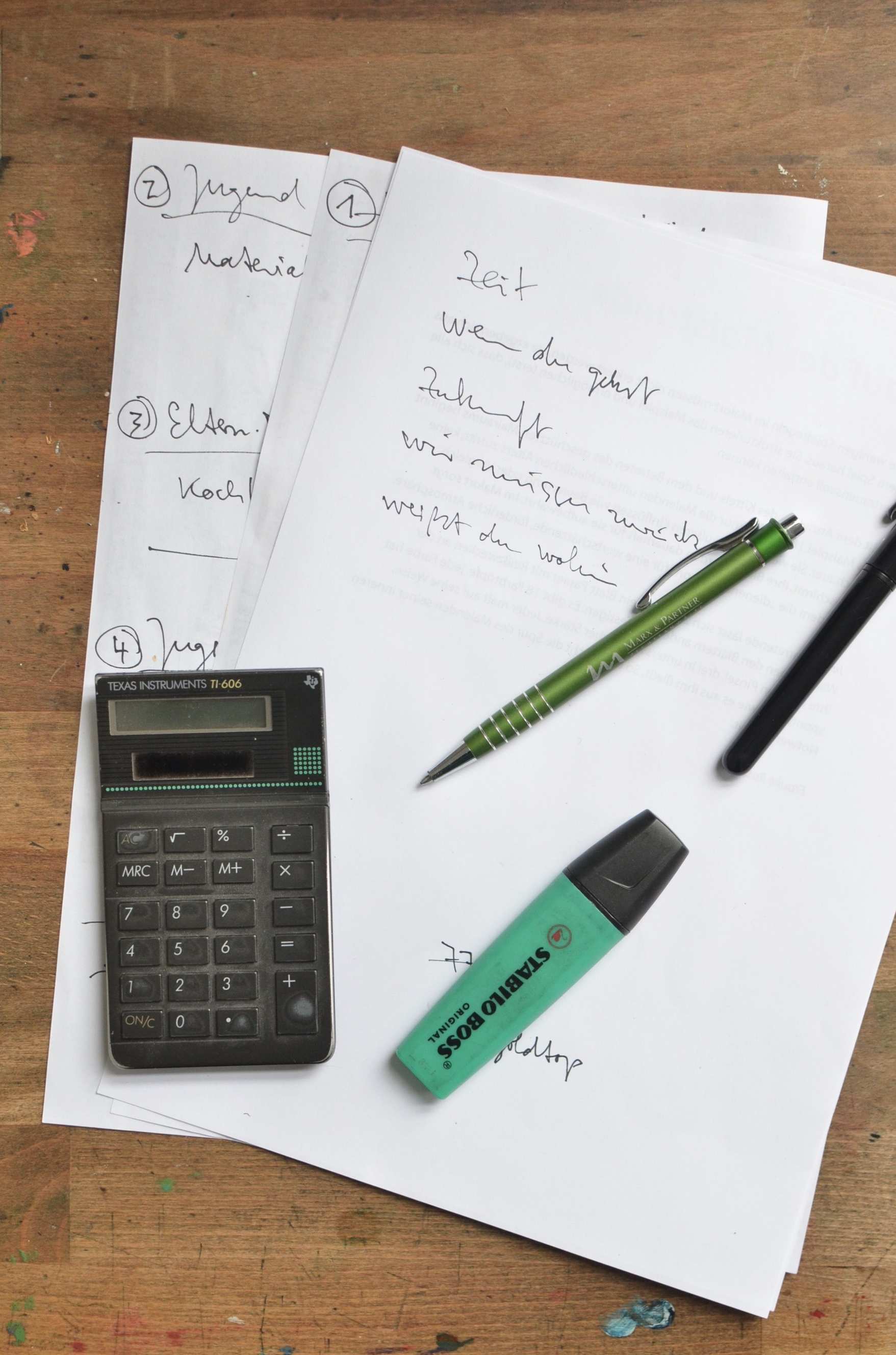 Belege und Tabellenansicht von oben auf einem Tisch — Stift und Taschenrechner auf Papier mit handschriftlichem Plan
